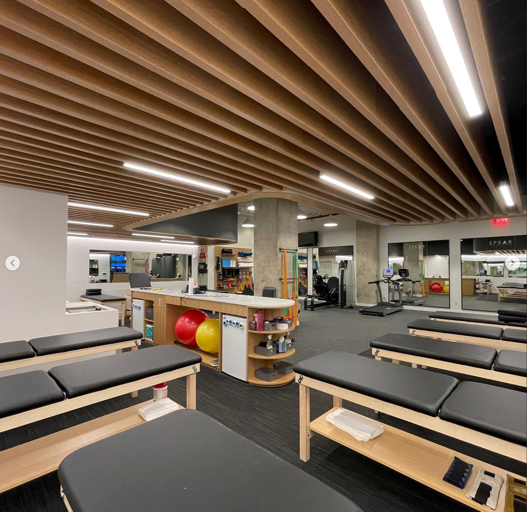 TechoLED BX-2 direct linear LED fixtures surface mounted in a gym. Features 90CRI Samsung LEDs, integral drivers, and aluminum extrusions in a seamless architectural pattern.