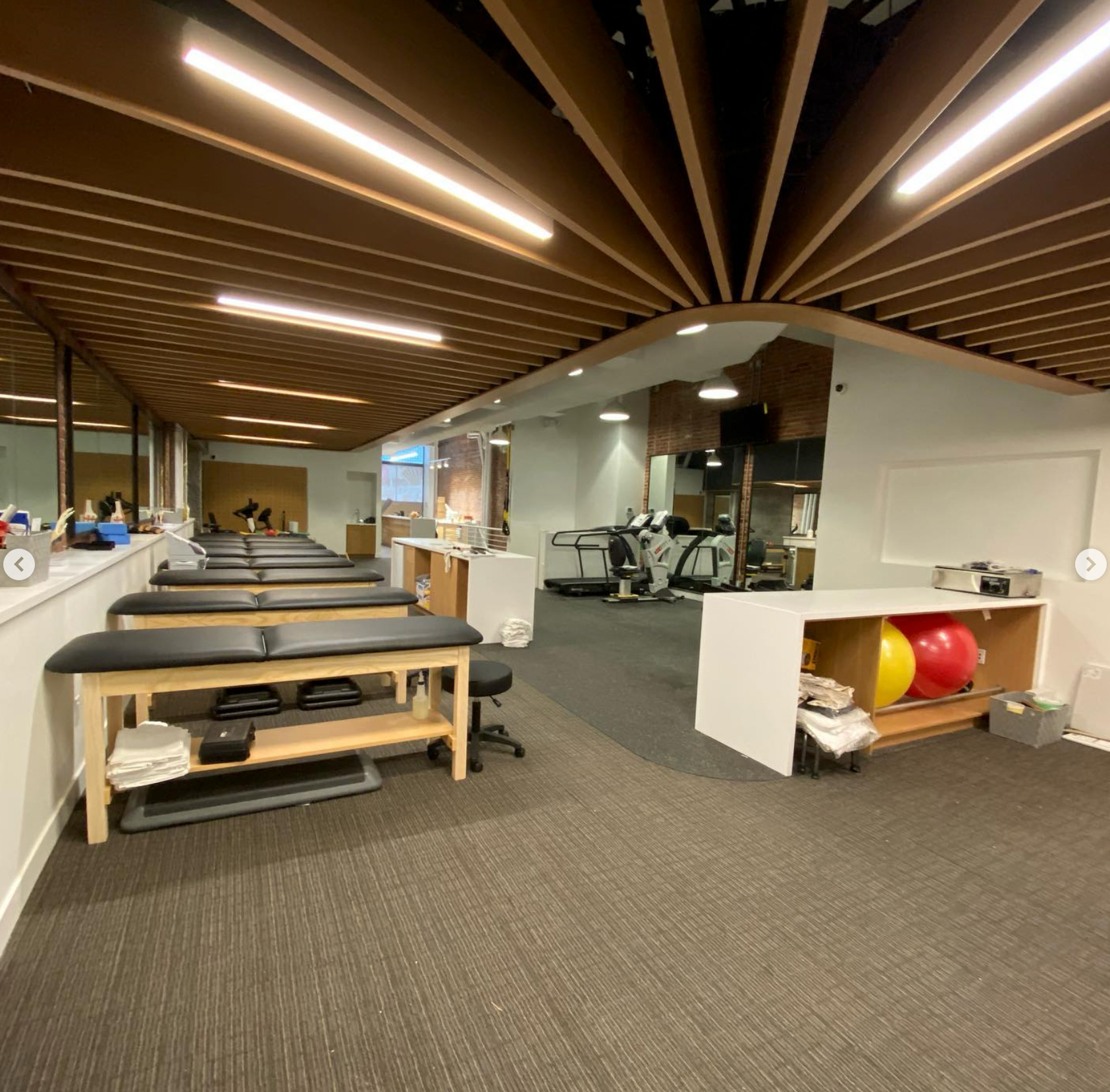 TechoLED BX-2 direct linear LED fixtures surface mounted in a gym. Features 90CRI Samsung LEDs, integral drivers, and aluminum extrusions in a seamless architectural pattern.